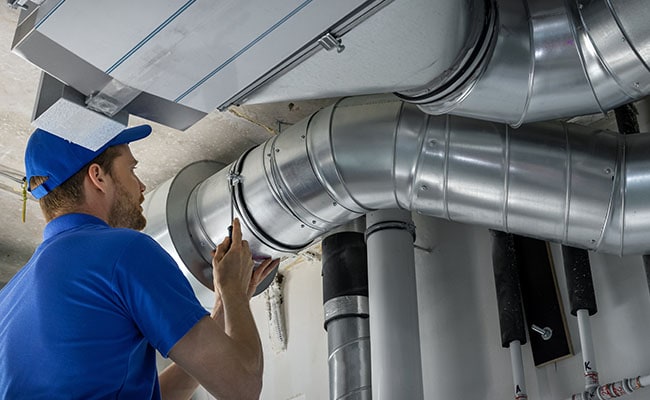 Technician repairing metal ductwork