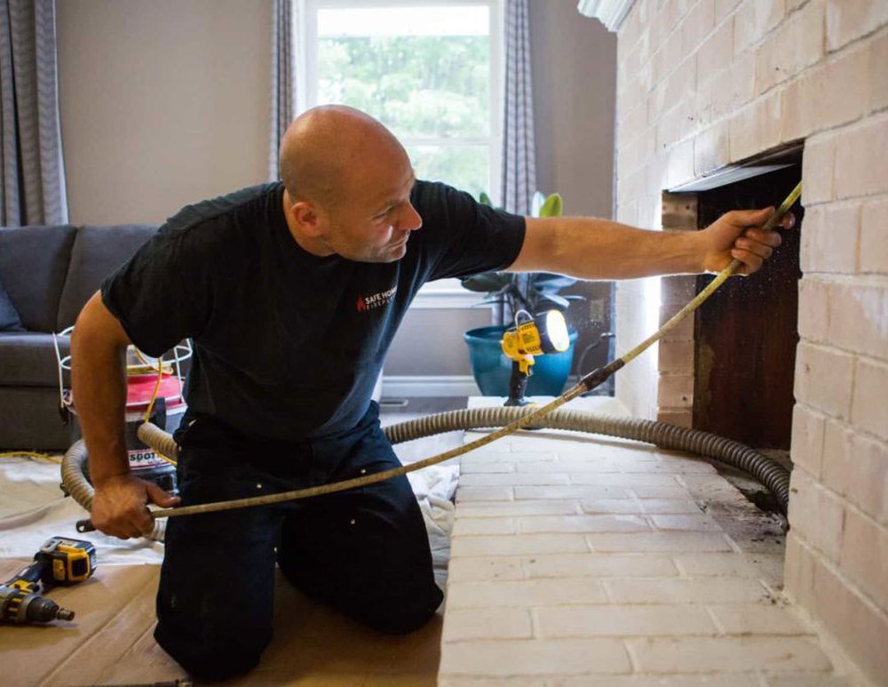 Technician sweeping a residential chimney